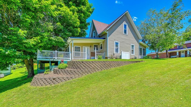 A two-story house with a covered porch, a stone retaining wall, and a well-maintained lawn. - 'the Shady Cottage' < 1 Mi to Downtown Millersburg (Millersburg)
