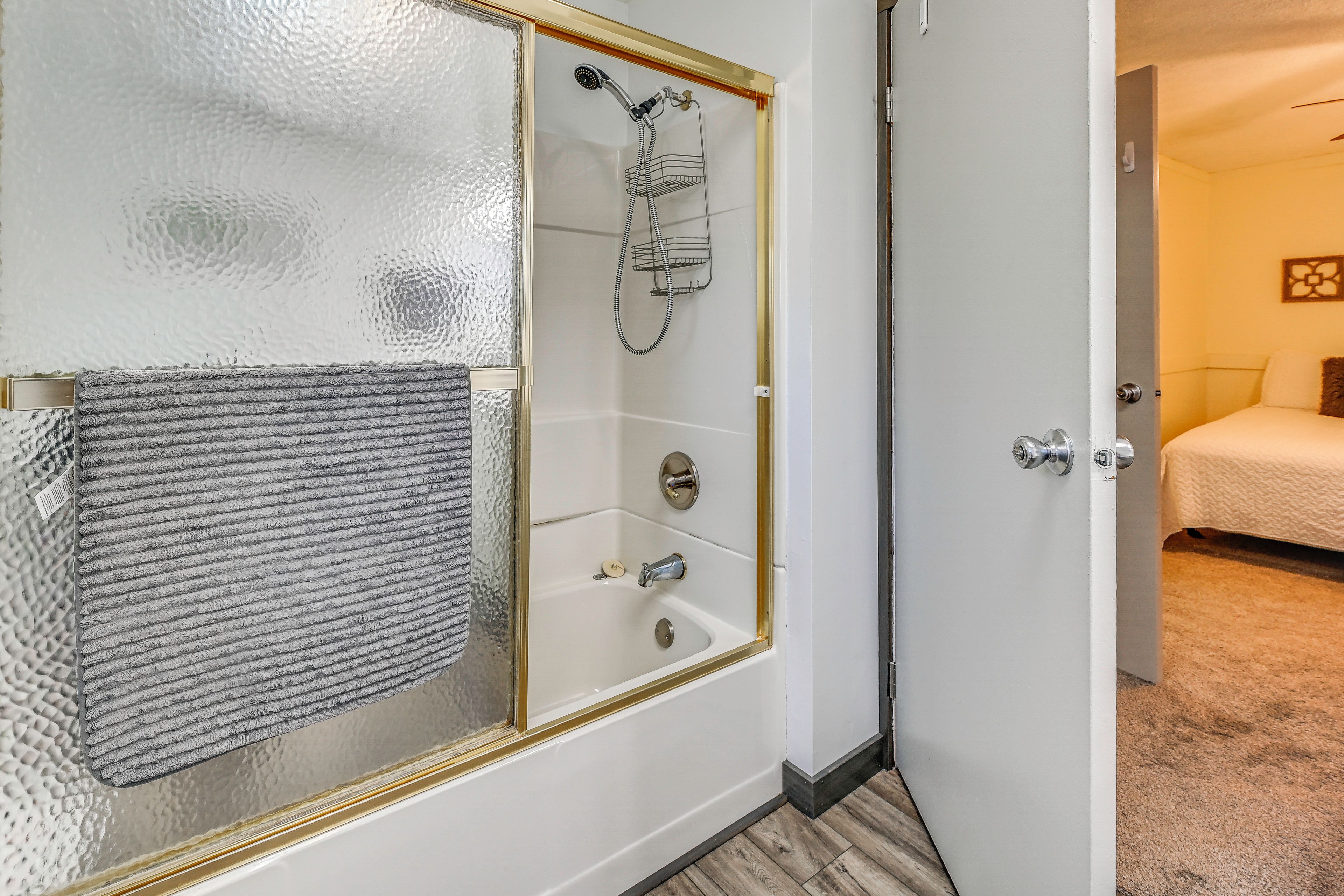 A bathroom with a glass shower enclosure, a bathtub, and a toilet.