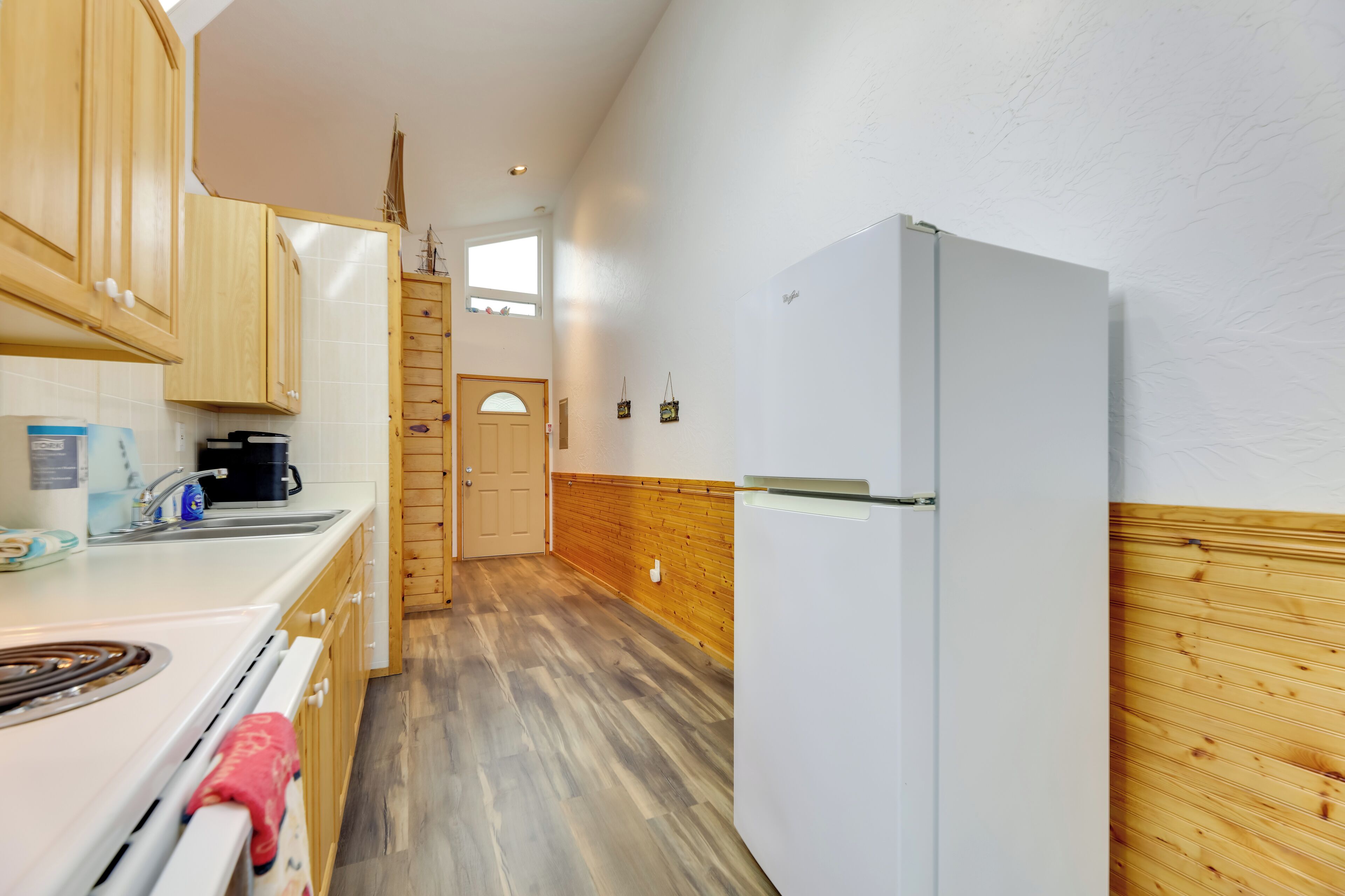 A kitchen with wooden cabinets, a white refrigerator, a stove, and a sink.