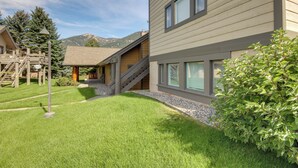 A modern building with a wooden deck, a staircase, and a well-maintained lawn. - Cozy Condo Near Golf, 7 Mi to Big Sky Resort! (Big Sky)