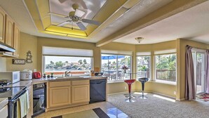 A kitchen with a central island, built-in oven, microwave, and dishwasher. There are large windows offering views of the outdoors. - Waterfront Discovery Bay Home: Outdoor Bar & Dock (Discovery Bay)