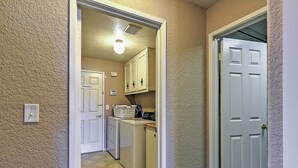 A laundry room with a washing machine, dryer, and cabinets. - Waterfront Discovery Bay Home: Outdoor Bar & Dock (Discovery Bay)