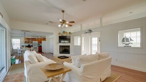 A spacious living area with a white sofa set, a wooden coffee table, and a fireplace. - Bokeelia Island Oasis: Waterfront, Private Dock! (Bokeelia)