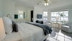 A bedroom with a bed, a TV, a desk, and a chair. - Bokeelia Island Oasis: Waterfront, Private Dock! (Bokeelia)