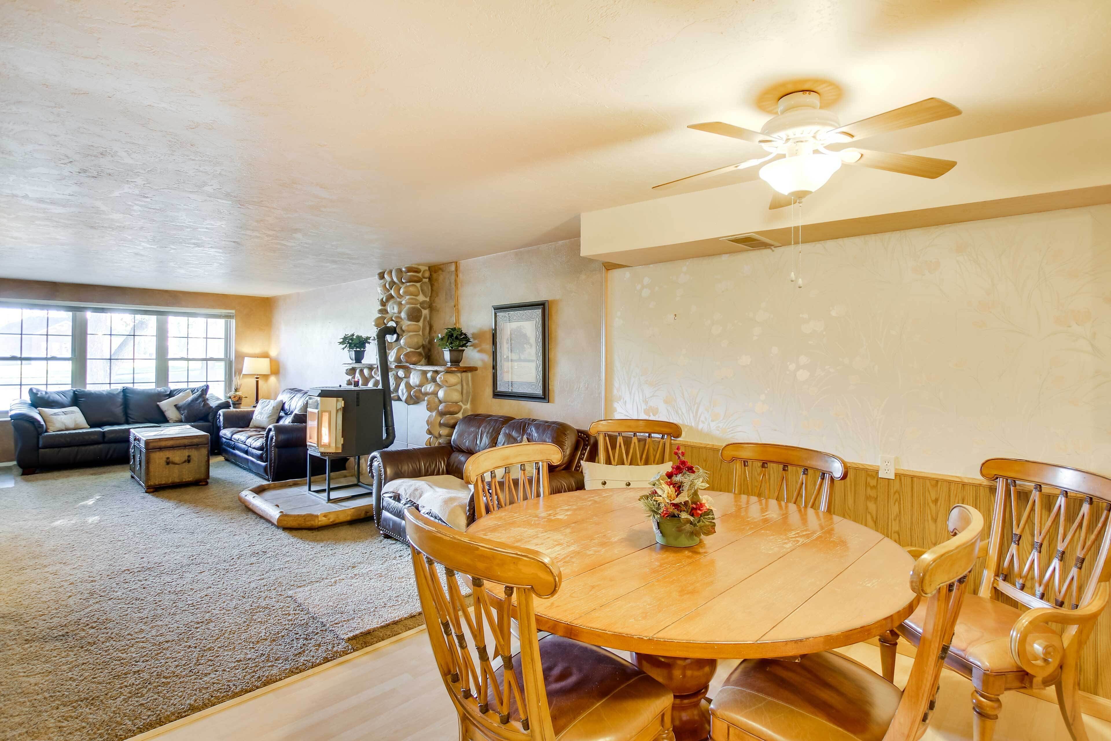 A cozy living room with a wooden dining table, leather sofas, and a stone accent wall.