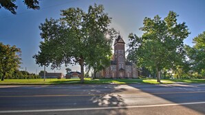 A church with a prominent tower, surrounded by trees and a clear sky. - Main Street Townhome - 12 Miles to Bear Lake! (Paris)