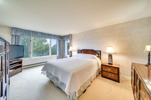A bedroom with a bed, a television, a dresser, and two bedside lamps. - Charming Retreat w/ Deck ~ 4 Mi From Casco Bay! (Orrs Island)