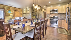 A log cabin interior with a dining area, kitchen, and staircase. - Dock w/ Boat Slip: Cozy Cabin Near Leesville Lake! (Pittsville)