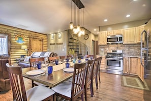 L’intérieur d’une cabane en rondins comprend un coin repas, une cuisine et un escalier.