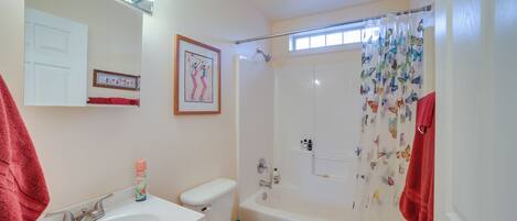 A bathroom with a sink, toilet, and bathtub.