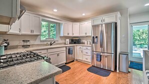 A modern kitchen with white cabinets, stainless steel appliances, and a granite countertop. - Hayesville Lake Getaway w/ Balcony & Mtn Views! (Hayesville)