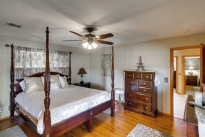 A four-poster bed with a ceiling fan, a dresser, and a nightstand with a lamp. - Spacious Lancaster Family Ranch - BBQ & Patio (Lancaster)