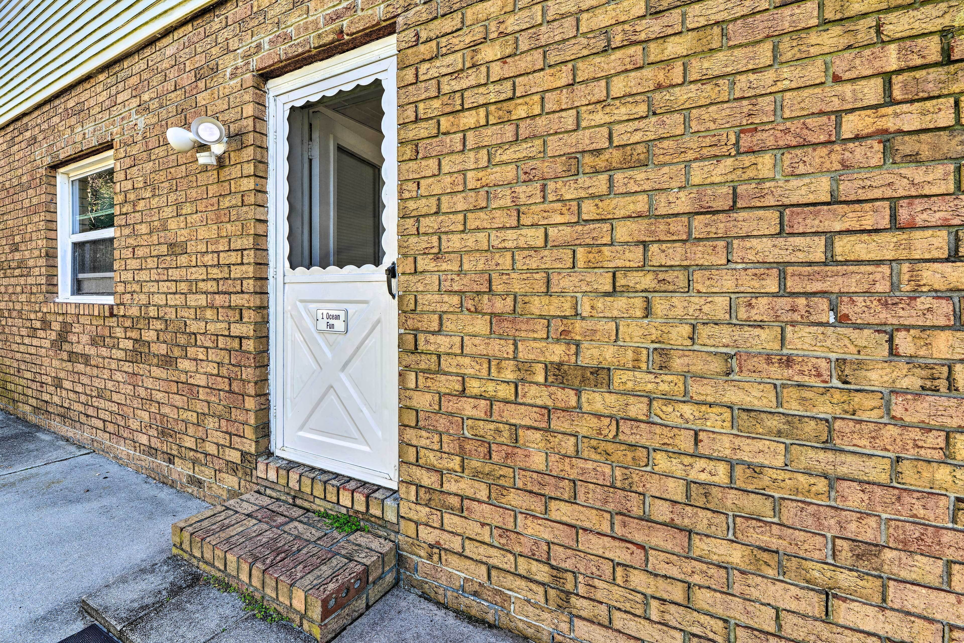 A brick building with a white door and a small window.