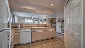 A modern kitchen with a central island, built-in appliances, and a large window providing natural light. - Branson Condo w/ Sunroom Near Downtown! (Branson)