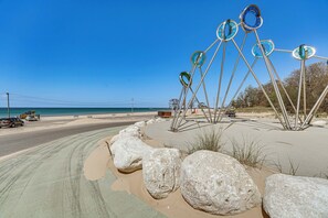 Una escultura junto a la playa, con rocas grandes y una vista despejada del océano.
