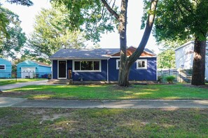 A single-story house with a front porch, a garage, and a small front yard. - Walk to Beach: Lake Michigan Getaway! (Muskegon)