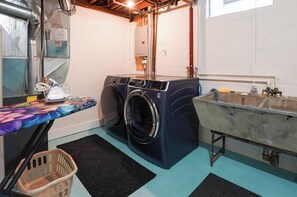 A laundry room with a washing machine, a sink, and a drying rack. - Walk to Beach: Lake Michigan Getaway! (Muskegon)