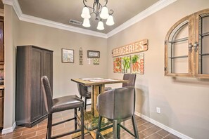 A dining area with a wooden table, four chairs, and a chandelier. - Inviting Amarillo Gem Near Palo Duro Canyon! (Amarillo)
