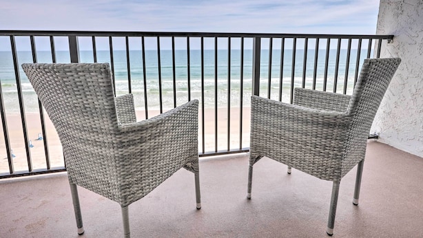 Two wicker chairs on a balcony with a view of the beach and ocean. - Oceanfront Retreat w/ Beach & Resort Access! (Daytona Beach Shores)