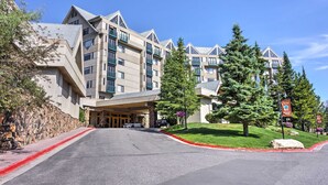 A multi-story hotel with a stone facade, a covered entrance, and a landscaped driveway. - Big Sky Condo w/ Mountain Views, Hike, Ski & Fish! (Big Sky)
