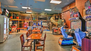 An indoor play area with tables and chairs, a climbing structure, and arcade games. - 10 Mi to Disney: Resort Getaway w/ Balcony! (Davenport)