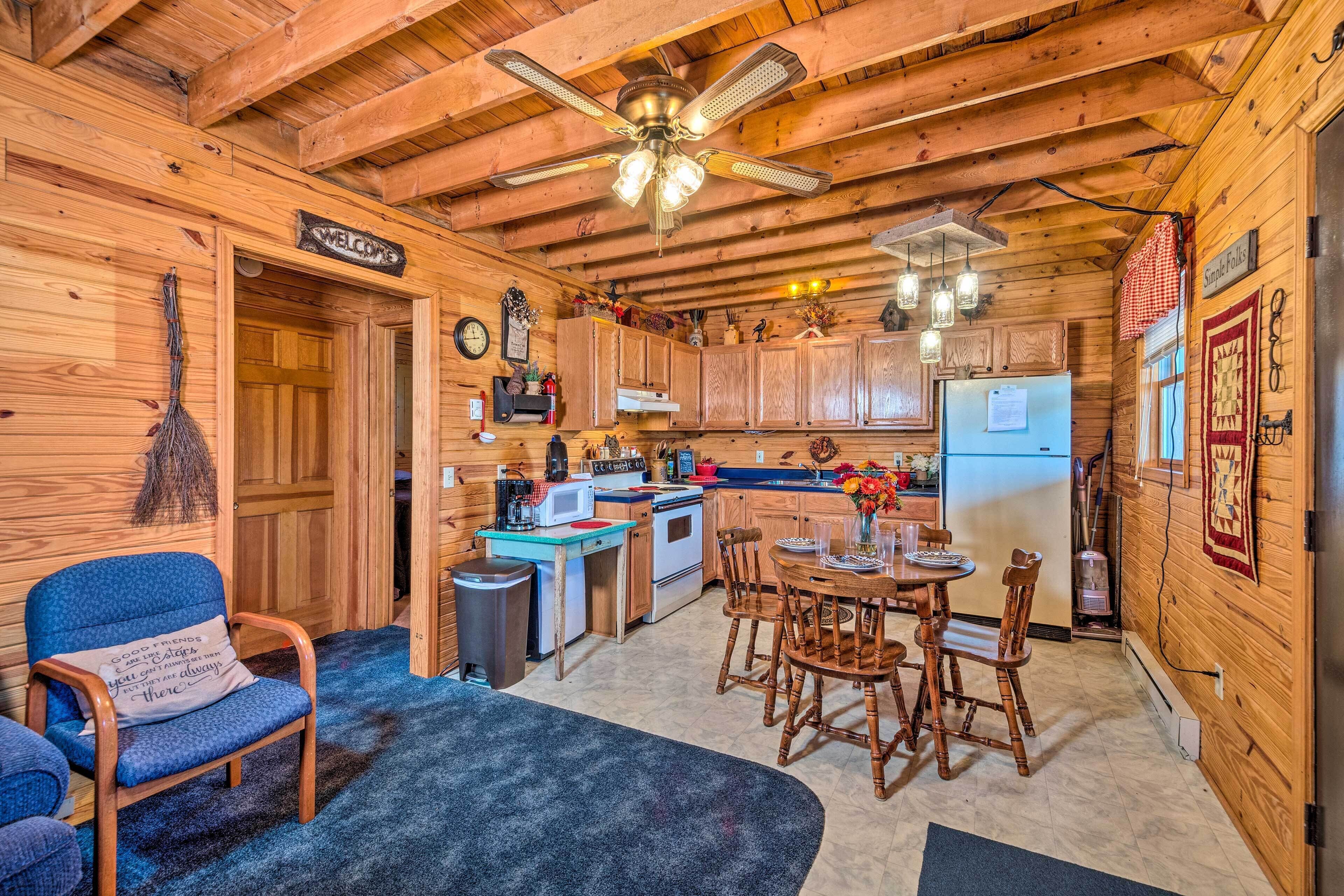 Ein gemütliches Blockhauss-Interieur mit Küche, Essbereich und Wohnraum mit Kamin.
