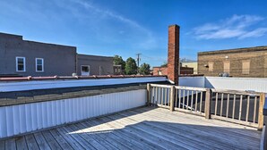 Eine Dachterrasse mit Holzboden und weißer Brüstung.