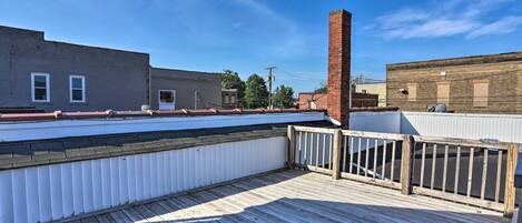 Eine Dachterrasse mit Holzboden und weißer Brüstung.
