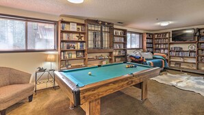 A pool table in a room with bookshelves, a sofa, and a television. - Rustic Western Home: Walk to Winchester Lake! (Winchester)