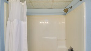 A bathroom with a bathtub, a shower curtain, and a handheld showerhead. - Myrtle Beach Condo w/ Lazy River: Walk to Beach! (Myrtle Beach)