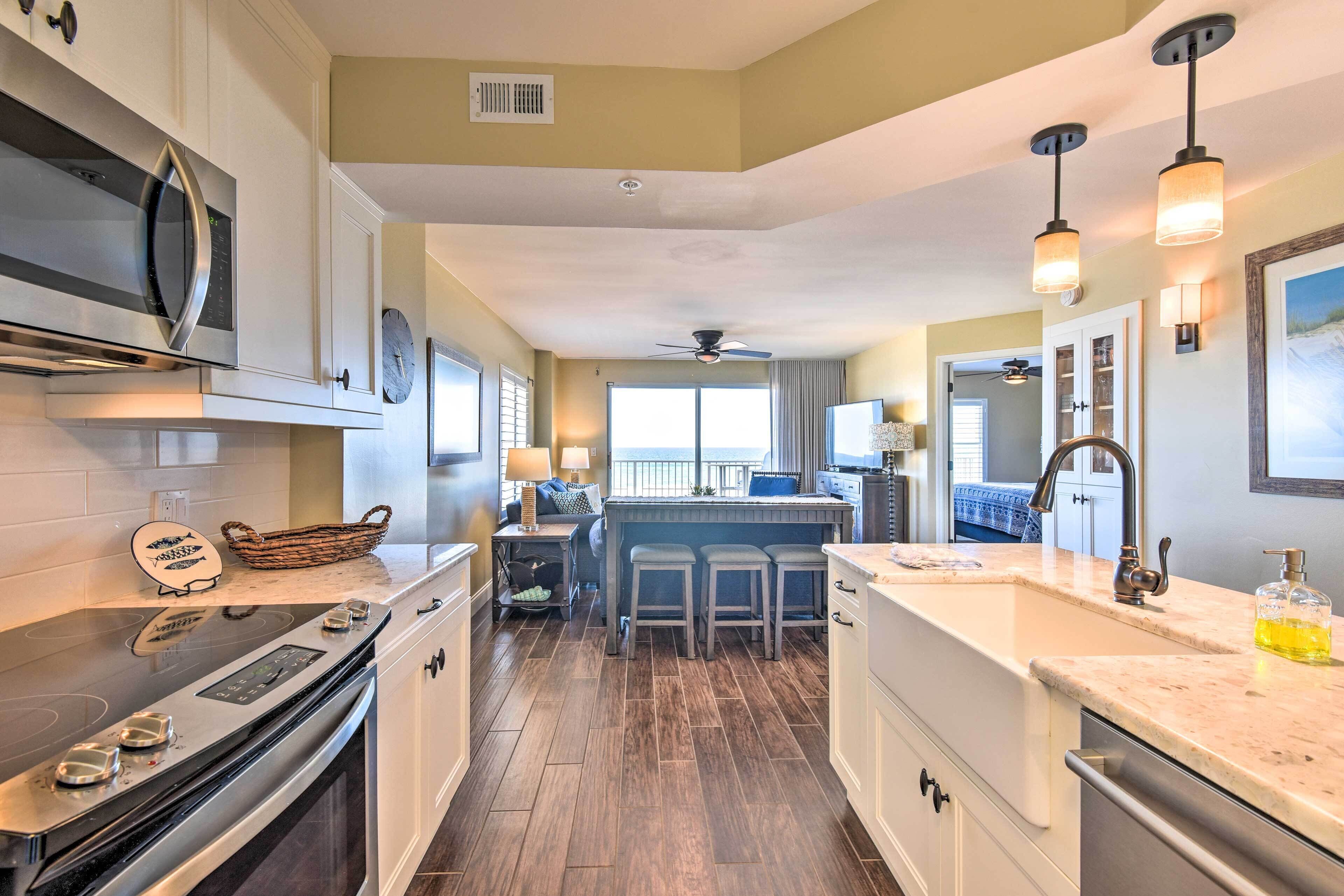 A modern kitchen with a central island, stainless steel appliances, and a dining area with bar stools.