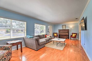 Ein Wohnzimmer mit grauem Sofa, Couchtisch und Klavier.