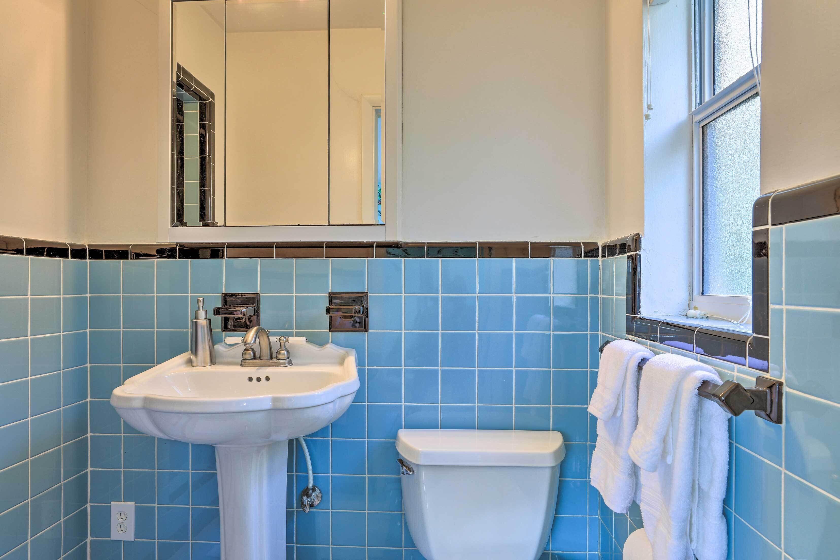 A bathroom with a white sink, a toilet, and a towel rack.