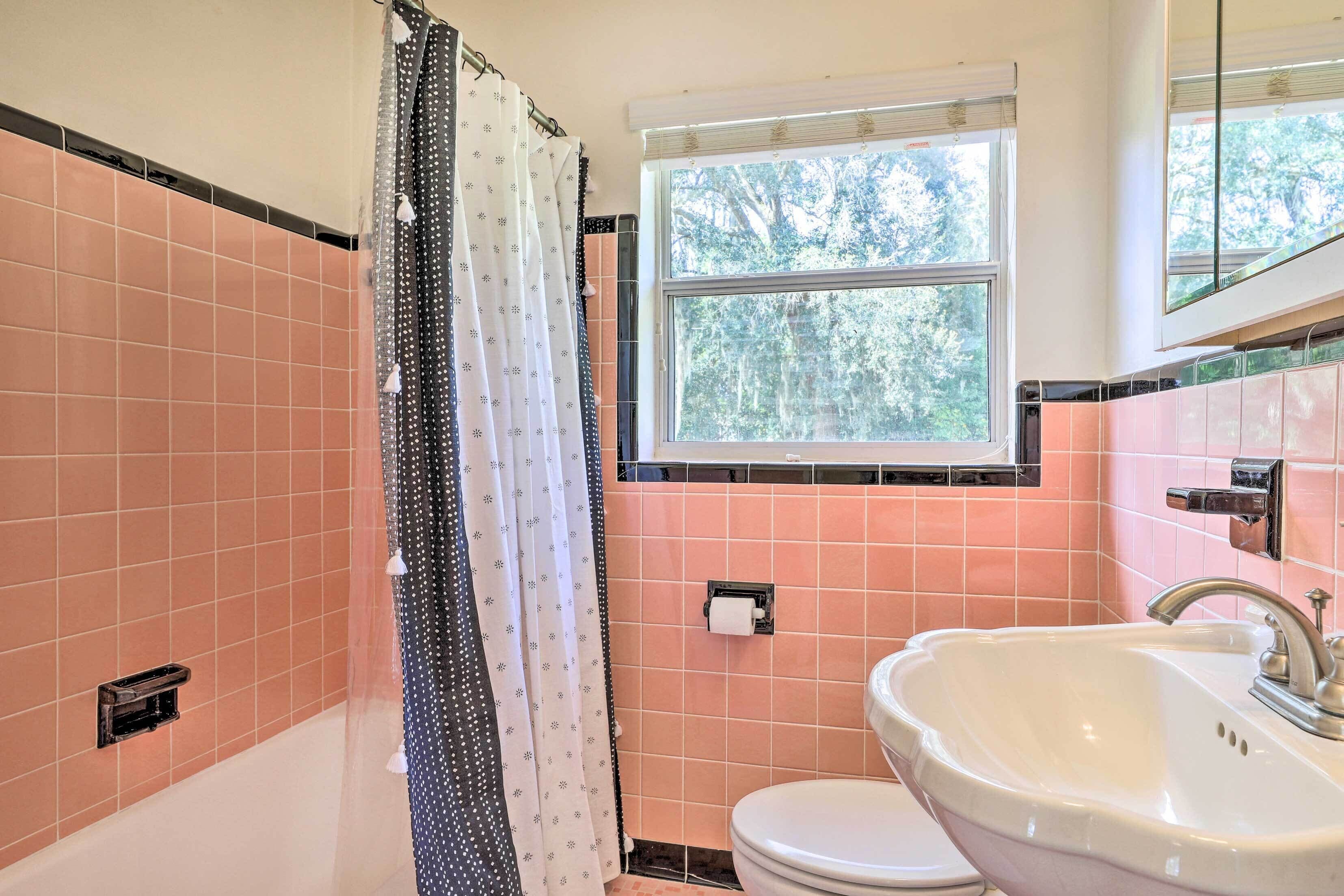 A bathroom with a bathtub, toilet, and sink.