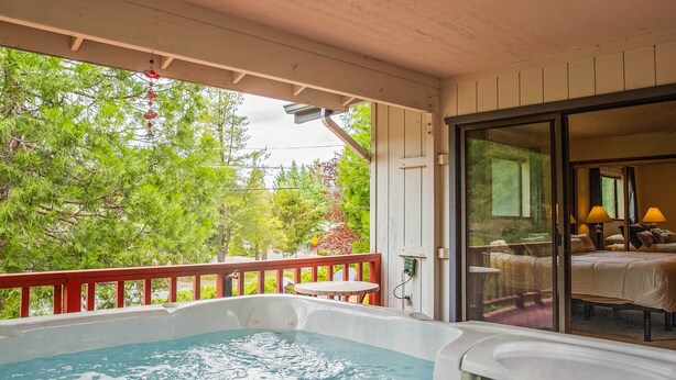 A hot tub area with a view of a bedroom and a balcony. - Deck & Hot Tub: Rustic Groveland Home! (Groveland)