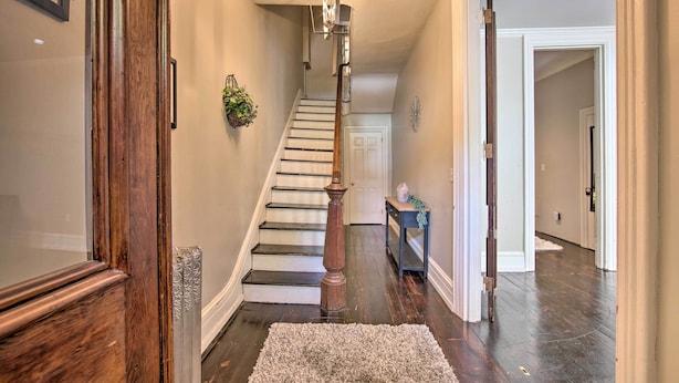 Un escalier avec une rampe en bois et un luminaire placé au-dessus.