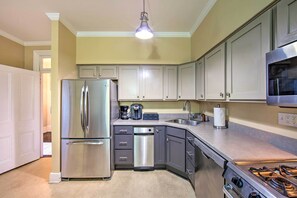 Una cocina con un refrigerador de acero inoxidable, lavavajillas y estufa.