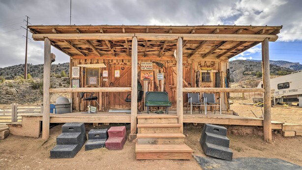 A rustic wooden structure with a porch, steps leading up to it, and a sign indicating a $500 fee. - 'cedar Mountain Hideout' By Cody Night Rodeo! (Cody)