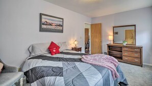 A bedroom with a bed, a dresser, a mirror, a nightstand, and a framed picture on the wall. - 'cedar Mountain Hideout' By Cody Night Rodeo! (Cody)