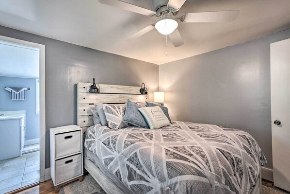 A bedroom with a bed, nightstand, dresser, ceiling fan, and a door. - Idyllic Waterfront Escape w/ Private Boat Dock! (Summerton)