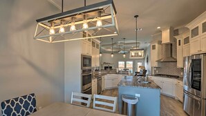 Een moderne keuken met witte kasten, roestvrijstalen apparatuur en een centraal eiland.