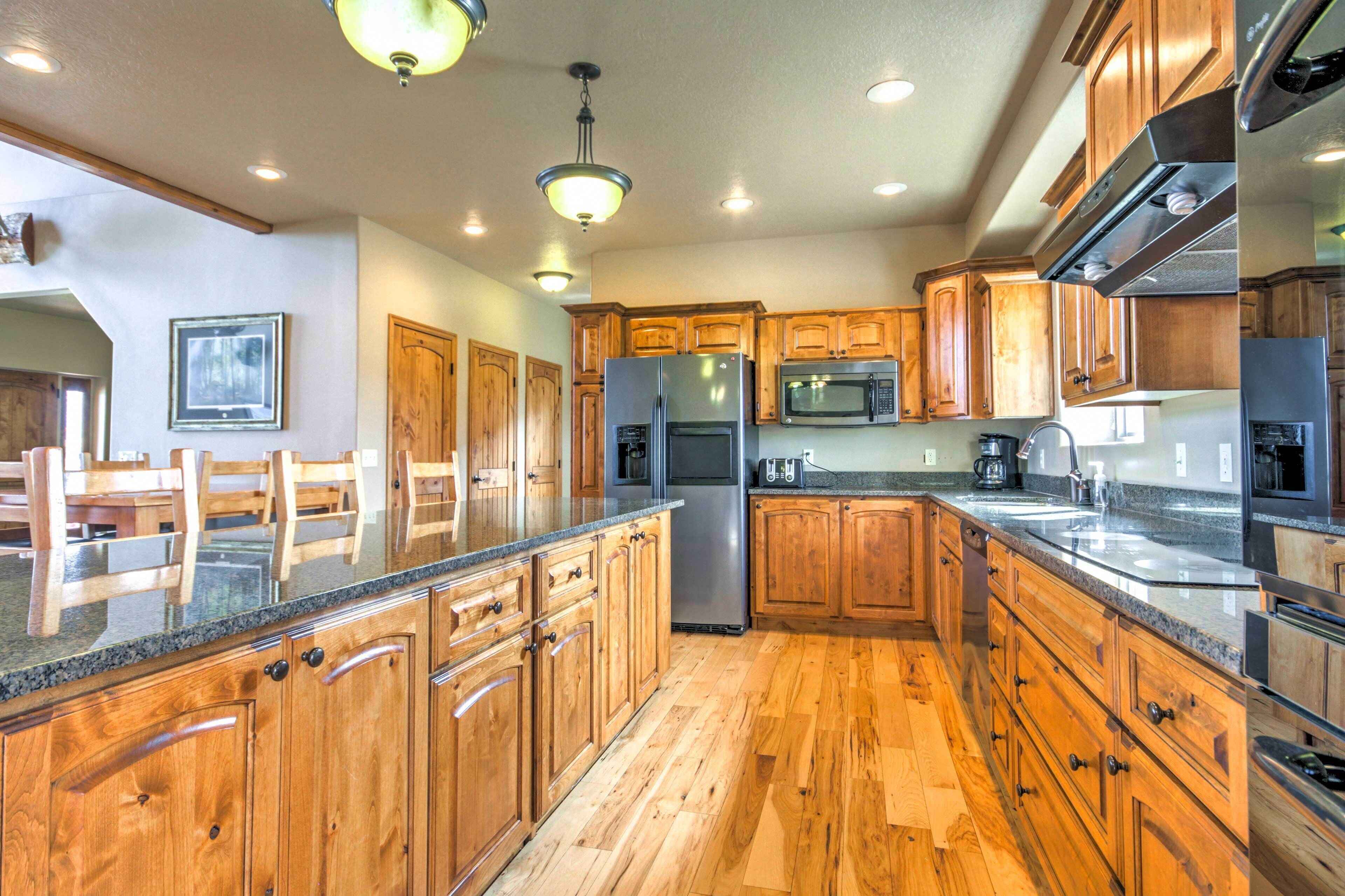 A kitchen with wooden cabinets, stainless steel appliances, and a granite countertop.