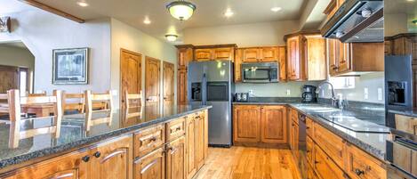A kitchen with wooden cabinets, stainless steel appliances, and a granite countertop.