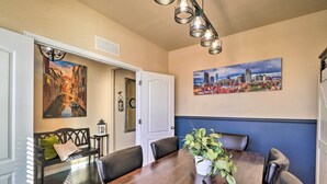 A dining area with a wooden table, black leather chairs, a bench with cushions, and a potted plant. - Pet-friendly Parker House Rental w/ Home Gym! (Parker)