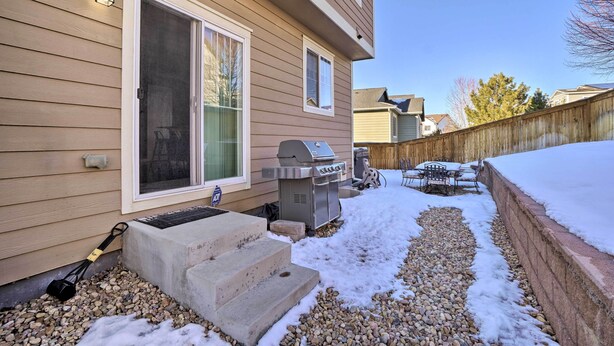 A backyard with a barbecue grill, outdoor seating, and a wooden fence. - Pet-friendly Parker House Rental w/ Home Gym! (Parker)