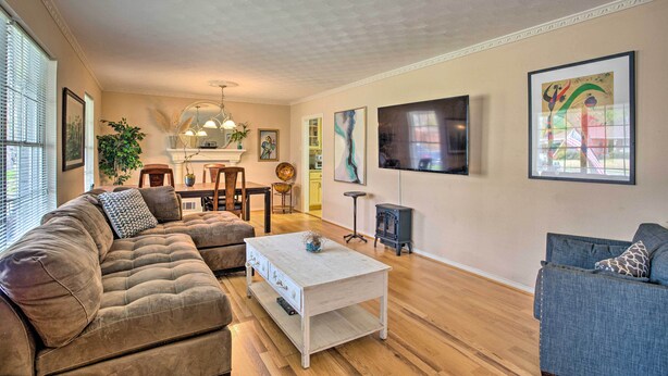 A living room with a sectional sofa, a coffee table, a TV, and artwork on the walls. - 8 Mi to Lake Ray Hubbard: Creekside Garland Home (Garland)