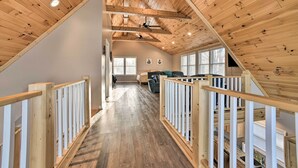 Un loft spacieux avec des poutres apparentes, un plafond haut et une vue sur l’espace de vie.