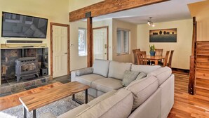 A cozy living room with a sectional sofa, a wooden bench, a fireplace, and a dining area with a table and chairs. - Peaceful Edwards Condo w/ Mountain Views! (Edwards)