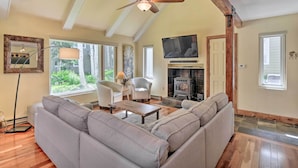 A spacious living room with a large sectional sofa, a ceiling fan, a fireplace, and a television mounted on the wall. - Peaceful Edwards Condo w/ Mountain Views! (Edwards)