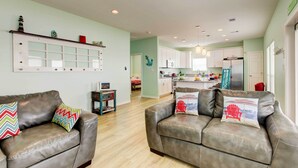 Un salón moderno con un sofá de cuero marrón, almohadas coloridas y una mesita auxiliar con un objeto decorativo.
